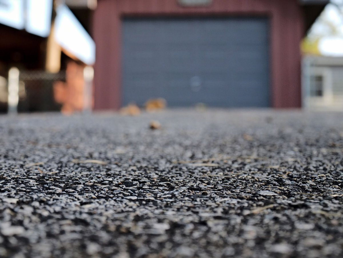 Asphalt driveway leading to garage in late evening light