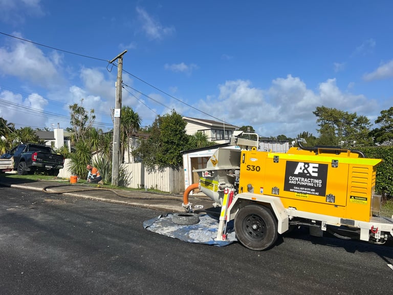 Yellow mobile service truck parked on residential street with operator working on ground infrastructure